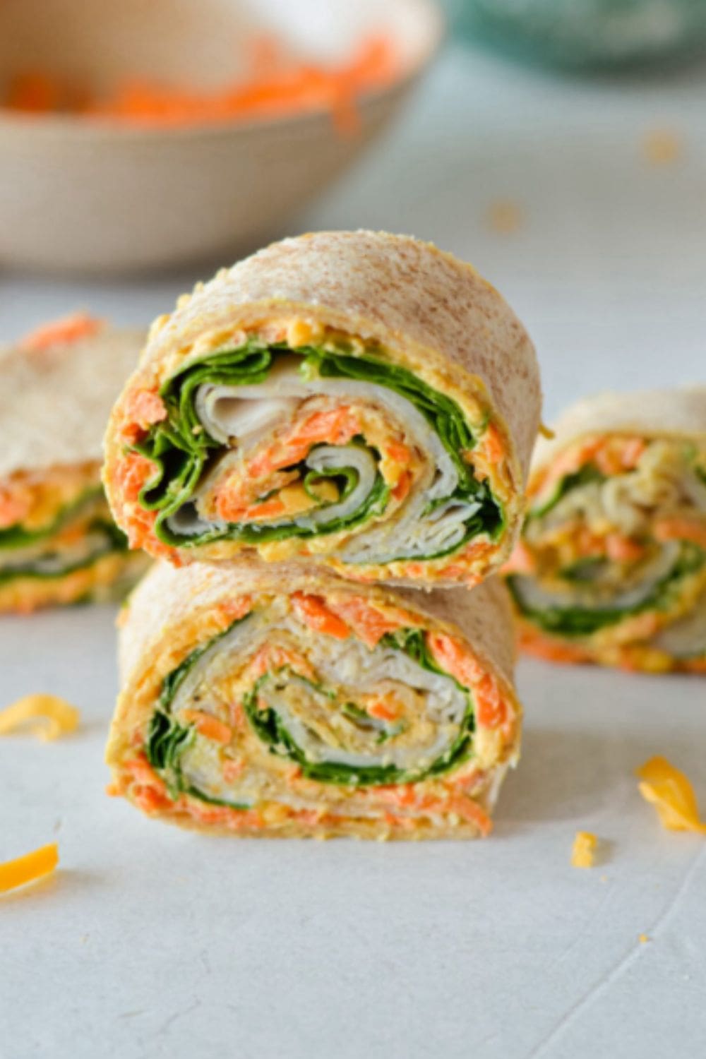 Turkey and cheese roll-ups sliced in half with greens inside, making an easy lunch that works well for weight watchers recipes and busy days.