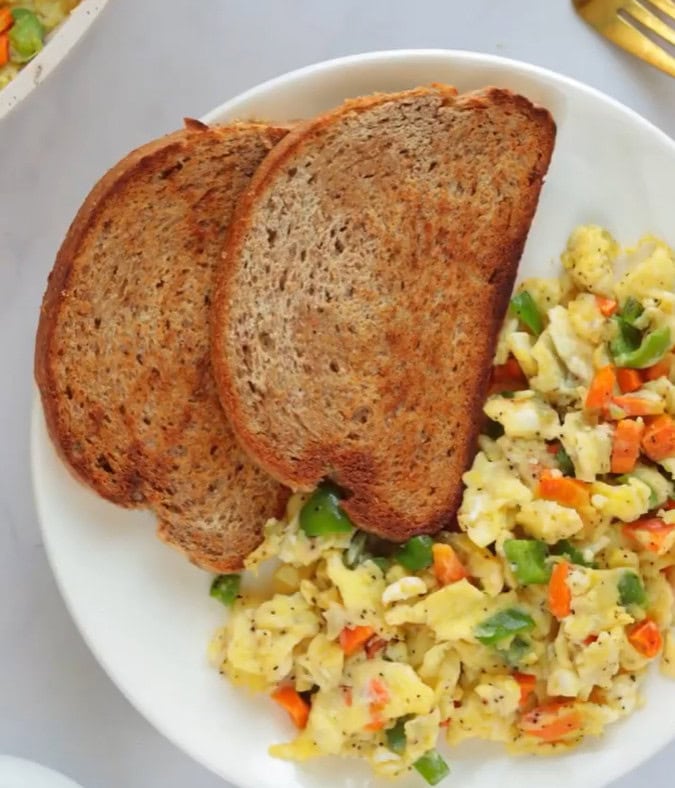Veggie Scrambled eggs on white plate with toast
