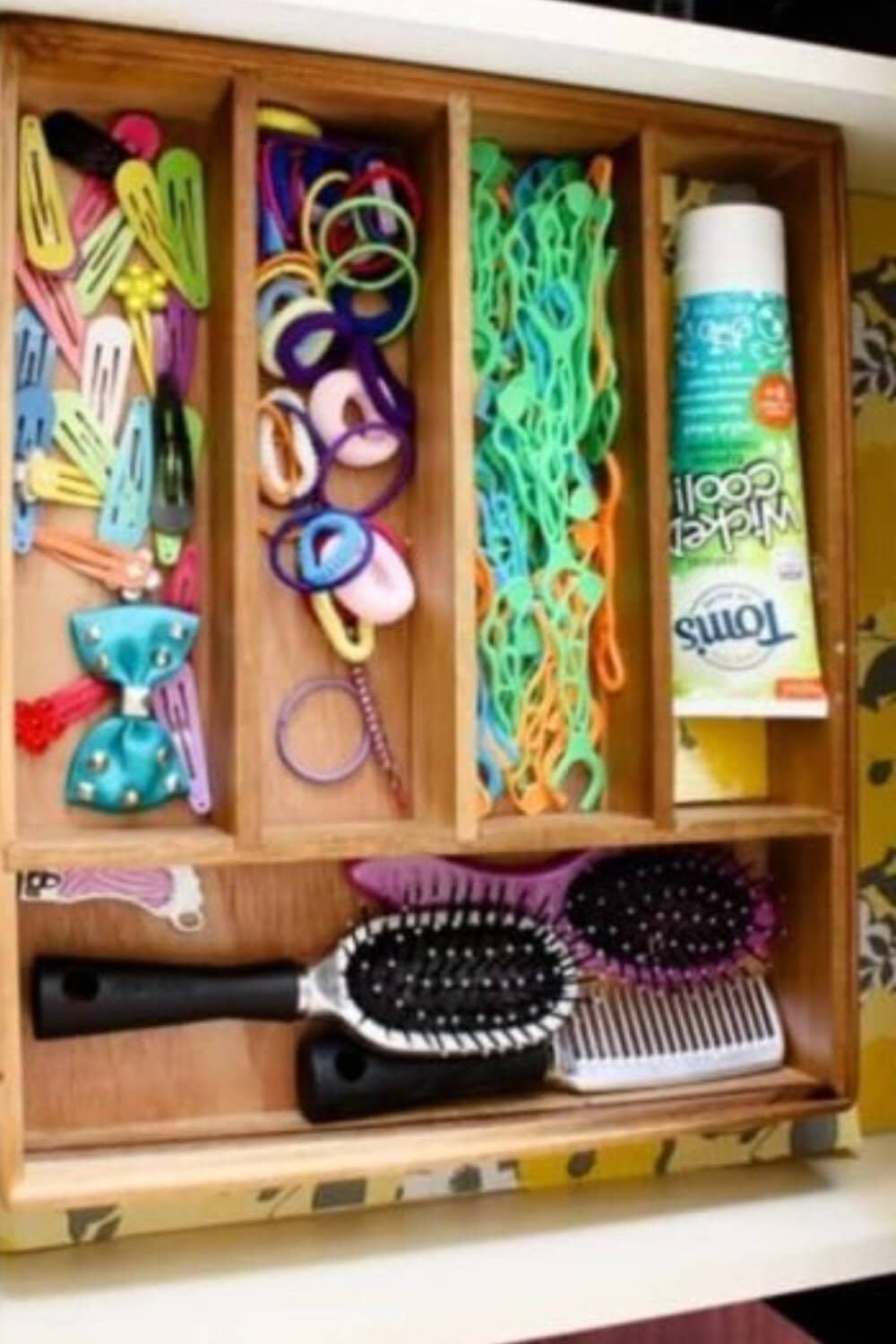 Cutlery tray in drawer filed with hair brushes, toothpaste, bows and clips