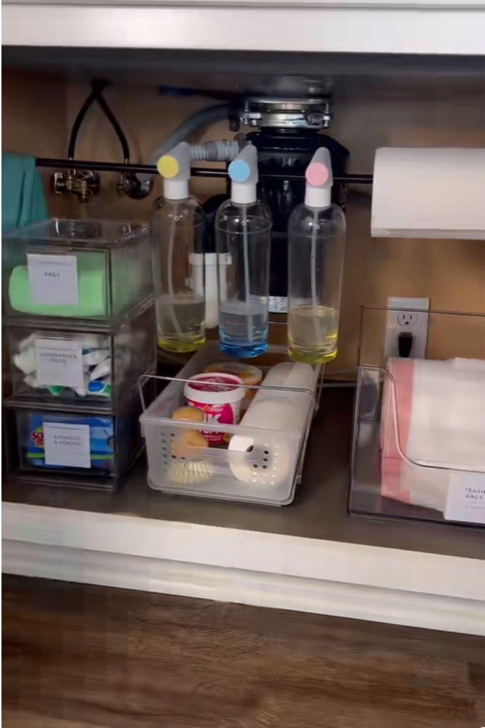 Tension rods used inside cabinets to hold spray bottles, a smart dollar store hack that makes awkward spaces actually useful.