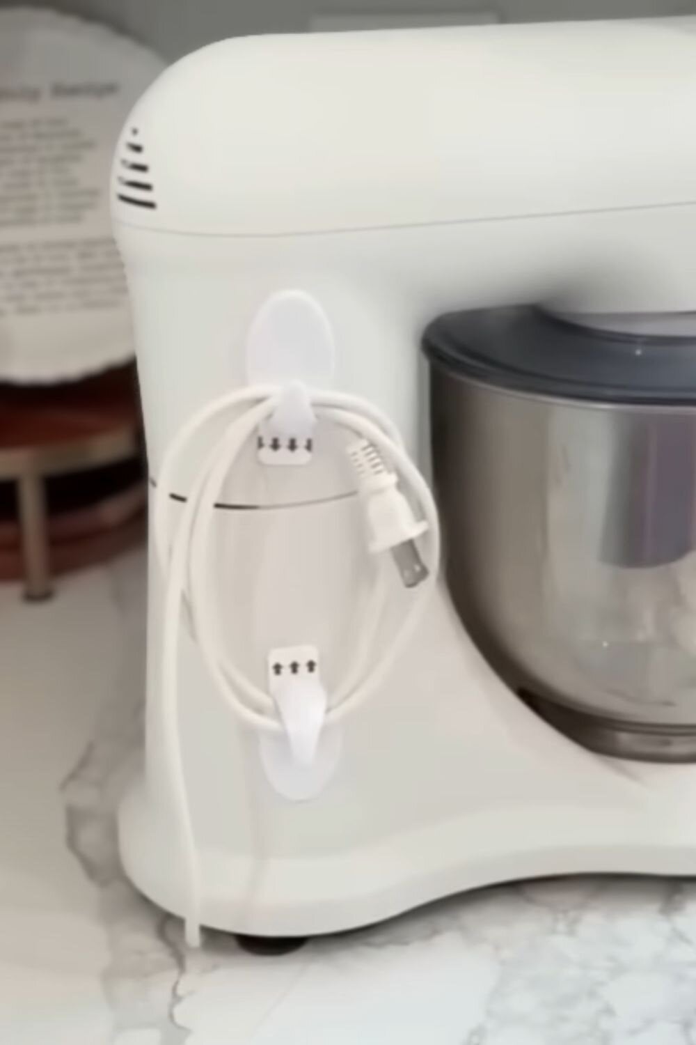 Adhesive hooks used to wrap and store appliance cords, one of those easy dollar store hacks that keeps cabinets tidy and cords from getting tangled.