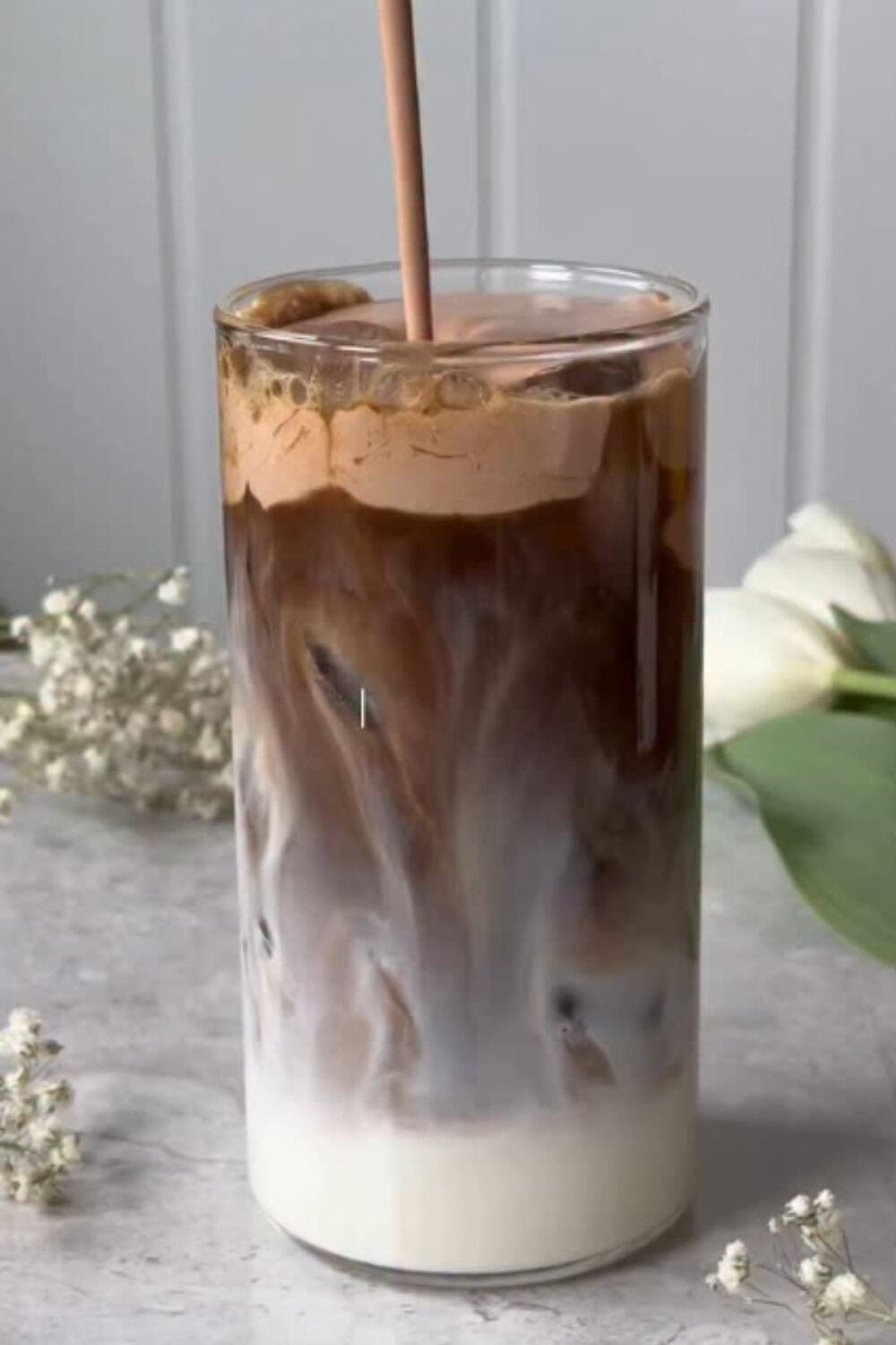 Iced coffee recipe layered with milk and whipped Nutella coffee, creating rich chocolate swirls in a tall glass.
