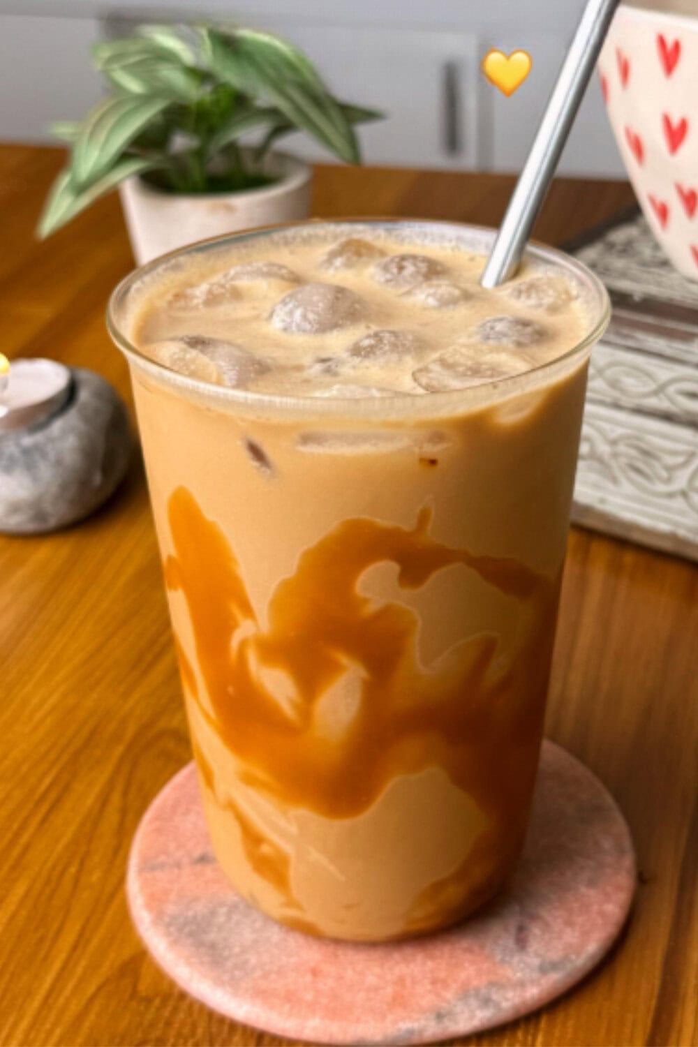 Iced coffee recipe featuring a caramel-drizzled iced drink in a clear cup with a metal straw and a smooth, creamy finish.