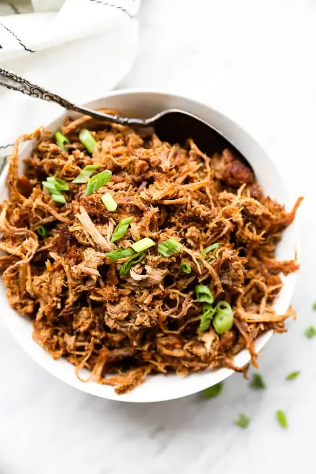 Slow cooker pulled pork served with vegetables, a high protein low calorie dinner idea